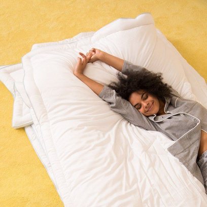 A woman waking rested on white bedding